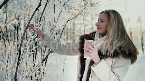 迷人的女人在冬天在户外喝咖啡视频的预览图