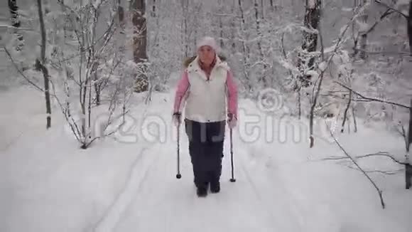 老妇人在树林里度过闲暇时间冬季森林支持物理活动的水平视频的预览图
