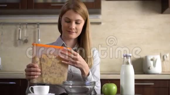 漂亮的年轻漂亮的女商人在厨房的碗里倒玉米片作为早餐视频的预览图