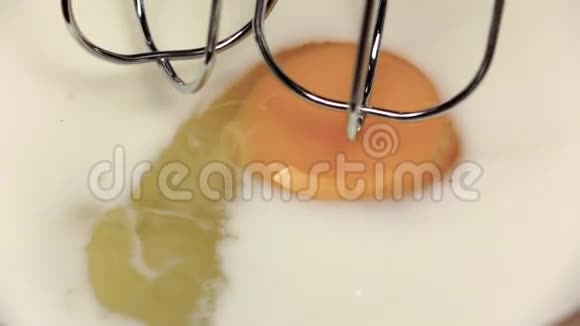 搅拌机鞭鸡蛋和牛奶在盘子特写慢动作视频的预览图