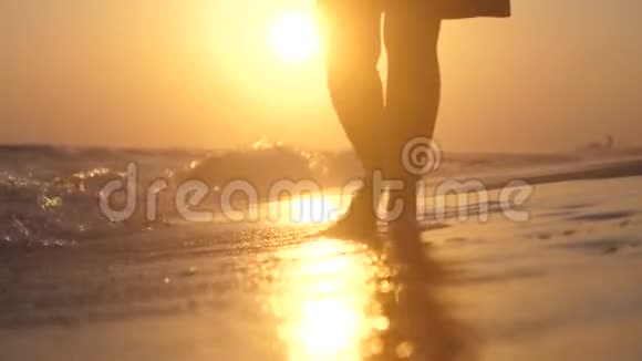 在金色的夕阳下雌性的脚在海滩上赤脚缓慢地行走快关门1920x1080视频的预览图