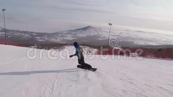 阳光明媚的一天年轻的滑雪者在高山滑雪胜地的斜坡上迅速滑下男子视频的预览图
