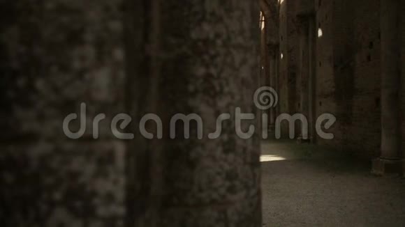 室内拍摄的一座古老的哥特式骑士教堂废墟被日落照亮视频的预览图