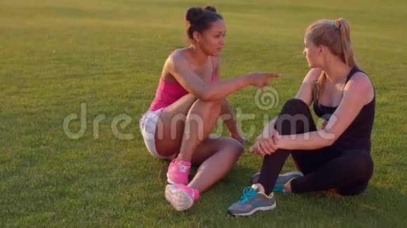 不同的女性朋友体育女孩在户外聊天草地上的年轻女子视频的预览图