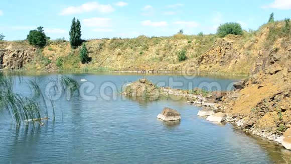 夏季美丽的湖泊景观有玄武岩岩石石头平静的水视频的预览图