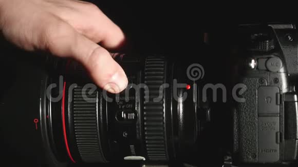 一个男人改变单反相机设置的镜头视频的预览图