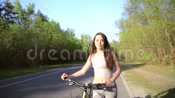 年轻的混血女子骑自行车骑着山地车在森林里散步疲惫的自行车锻炼户外视频的预览图