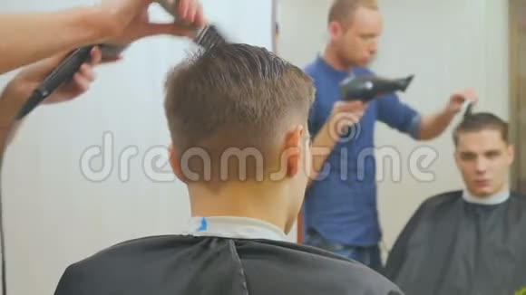 发型师在镜子前为年轻人做发型视频的预览图