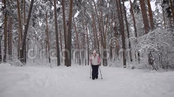 疲惫的女人试图做最后的努力然后离开雪林和放松穿着温暖保持自然在视频的预览图