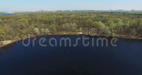 风景湖在森林里阳光明媚的天气里基辅市的外观在天际线上视频的预览图