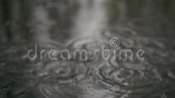 慢动作人行道上水坑里的雨滴视频的预览图
