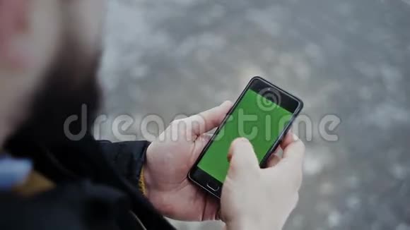 男人用智能手机滚动快乐地看照片视频的预览图