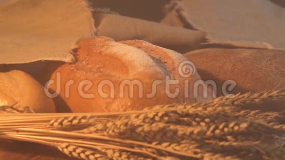 手工制作的美味面包躺在木桌上上面有面粉小麦和麦穗视频的预览图