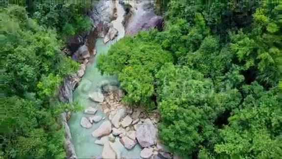 空中观景摄像机从丛林中的瀑布河向上移动视频的预览图