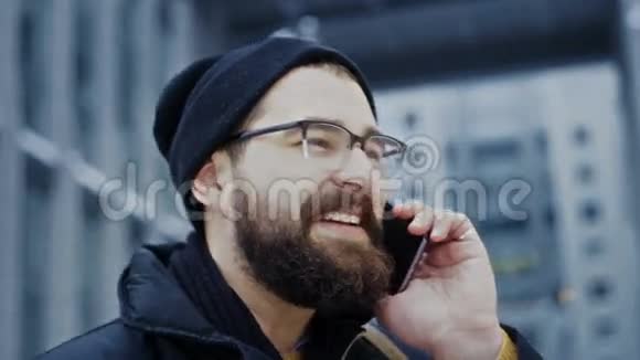 关闭智能手机男子在电话交谈微笑在商务中心前面视频的预览图