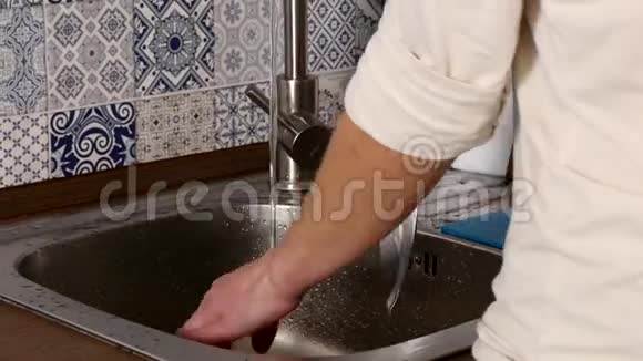 用自来水从厨房用人手洗盘子视频的预览图
