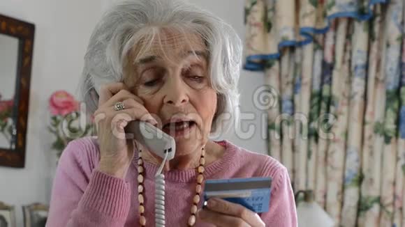 在电话中提供信用卡详细信息的高级女性视频的预览图