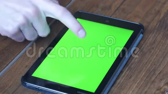 男子使用平板电脑与绿色屏幕的木制桌子与各种手势视频的预览图