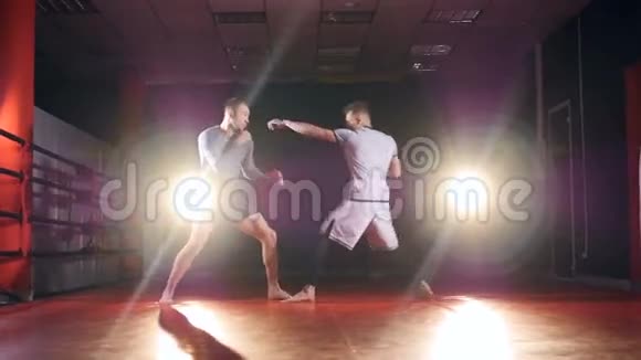 慢动作MMA战斗机在黑暗中在擂台上打斗视频的预览图