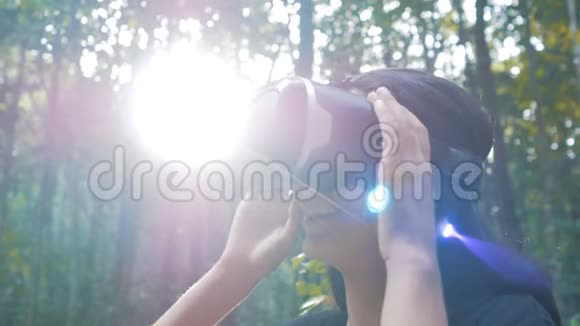 美丽的年轻黑发女人在丛林中使用虚拟现实眼镜视频的预览图