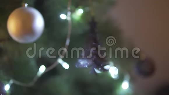 在节日的除夕气氛中关闭令人印象深刻的圣诞树装饰的散焦视图闪烁着明亮的光线视频的预览图