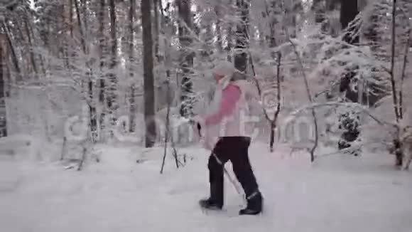 穿着冬季运动服的老年妇女很快就走上了道路她们用特殊的棍子在雪地里行走视频的预览图