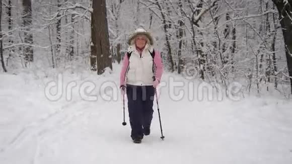 运动的成年女人自信地向前走她头上戴着兜帽看上去最近下雪了视频的预览图