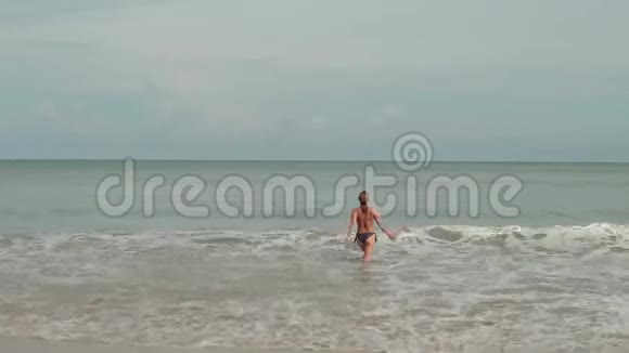 穿着比基尼在海浪中的年轻女性享受日光浴和海滩度假视频的预览图