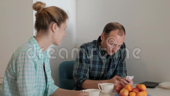 年轻的女人和男人在室内厨房里聊天视频的预览图