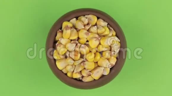 绿色筛网上分离的一个盆栽中玉米粒的旋转视频的预览图