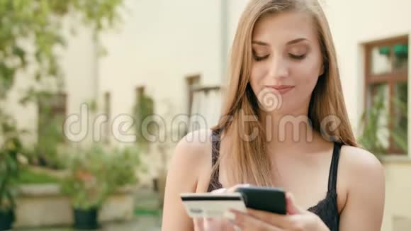 年轻女士用电话拿着信用卡视频的预览图