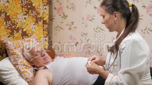 一位女医生在家里生病时给药那人正在喝水躺在沙发上视频的预览图