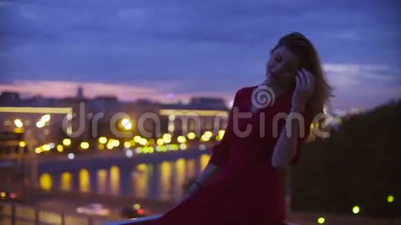 穿红色衣服的年轻女子坐在栏杆上视频的预览图