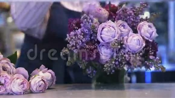 一个女人的花匠在做一束紫色的花潘射视频的预览图