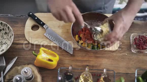 一位厨师将蔬菜沙拉混合并加入盐和香料的俯视图视频的预览图