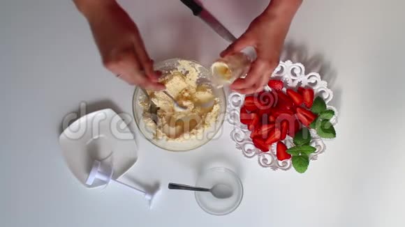 一个女人用奶油填充烹饪注射器碟子旁边是一个草莓视频的预览图