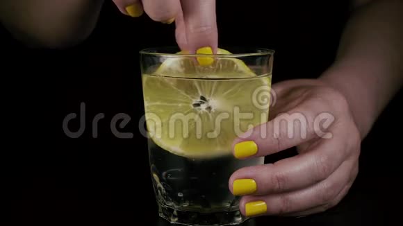 慢点一只雌手正在杯子里蘸一个柠檬视频的预览图