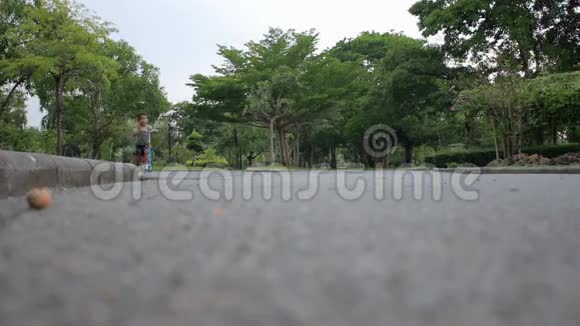 可爱的亚洲小女孩在公共公园玩滑板车视频的预览图