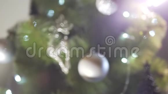 在节日的除夕气氛中在美妙的圣诞树装饰上关闭散焦景视频的预览图