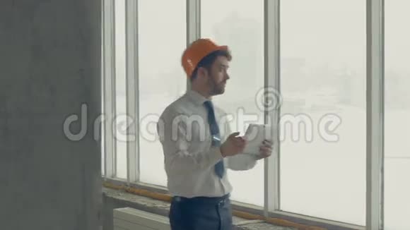 建筑大师戴安全帽的商人在一个建筑工地内用平板电脑检查施工进度滑块视频的预览图