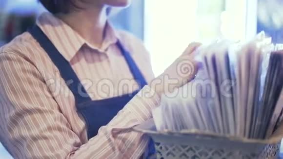 一位女售货员为一束花选择包装纸的侧面视图平底锅视频的预览图