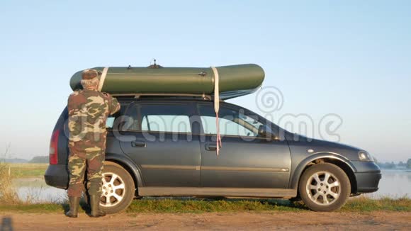 一个人把一艘充气船装到车顶上以便运输安全修复视频的预览图