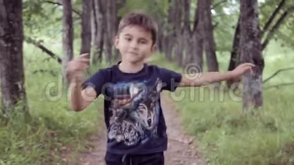 肖像一个快乐美丽的小男孩在夏天阳光明媚的日子在公园里散步视频的预览图