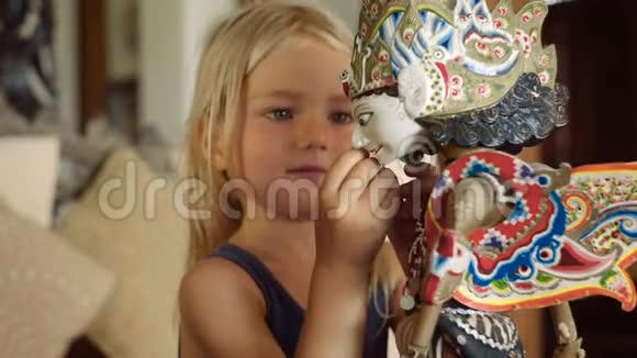小女孩在检查一个巴厘岛娃娃视频的预览图