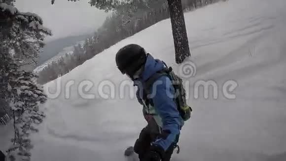 在视频画面上人们看到一个男人穿着温暖的冬装迅速而自信地滚动着雪山视频的预览图