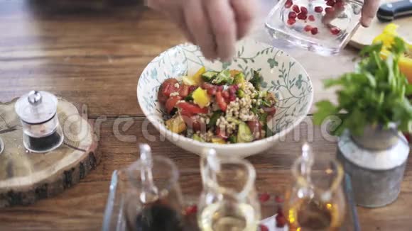 厨师在蔬菜沙拉中加入石榴酱汁和橄榄油视频的预览图
