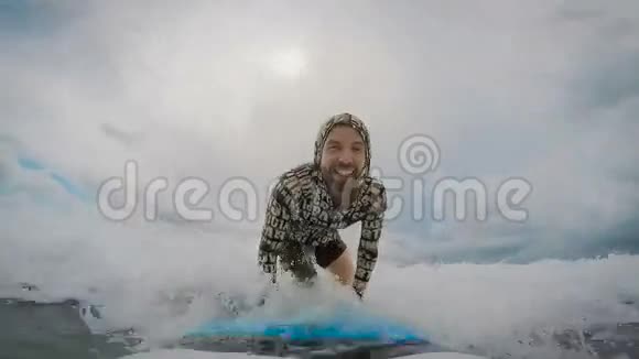 年轻人骑着冲浪板抓住一个小海浪然后掉进水里游客积极追求视频的预览图