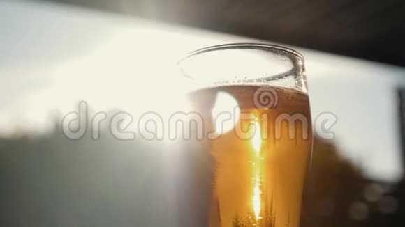一杯冰啤酒贴在天空一个黄色的夕阳视频的预览图