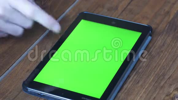 男子使用平板电脑与绿色屏幕的木制桌子与各种手势视频的预览图
