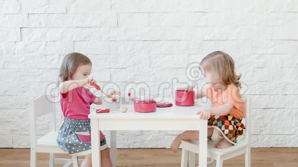 女孩们在白色的桌子上玩视频的预览图